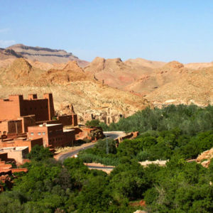 Sun drenched buildings are in the foreground of the beautiful Todgha Gorge in Morocco.