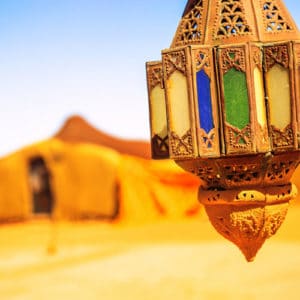 A colorful view of a nomad camp with a lamp in the forground.